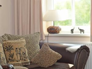 sala de estar con sofá con almohadas y ventana en Villa "To Hus" in Sellin - Appartement 05 im DG mit Kamin und Balkon, en Ostseebad Sellin
