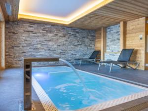 - une piscine avec 2 chaises à côté d'un mur de briques dans l'établissement Apartment Les Terrasses de Nendaz D1 by Interhome, à Nendaz 40 autres photos