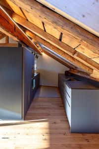 ObervazにあるApartment Ferienhaus Tgioc by Interhomeの木製の天井とデスクが備わる屋根裏部屋
