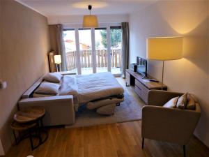 ein Schlafzimmer mit einem Bett, einem Sofa und einem Stuhl in der Unterkunft Apartment Clavan by Interhome in Crans-Montana
