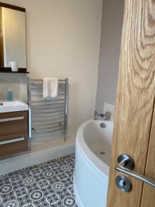 a bathroom with a bath tub and a sink at Melbourne Guest House in Bowness-on-Windermere