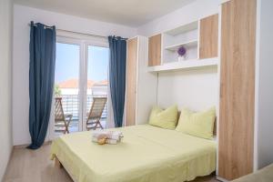 ein Schlafzimmer mit einem Bett und einem Balkon in der Unterkunft Apartmani Gabriella in Vodice