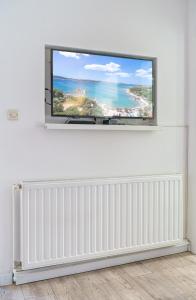 einen Flachbild-TV an einer weißen Wand im Wohnzimmer in der Unterkunft Apartmani Gabriella in Vodice