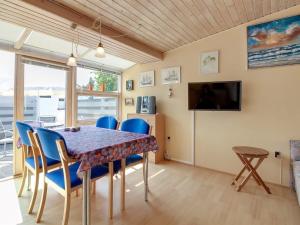 a dining room with a table and chairs and a television at Apartment Genadij - 1km from the sea in Western Jutland by Interhome in Vejers Strand