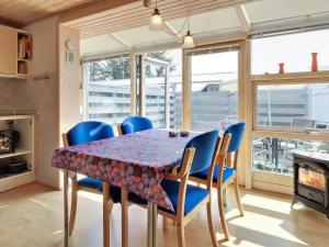 a dining room with a table and blue chairs at Apartment Genadij - 1km from the sea in Western Jutland by Interhome in Vejers Strand