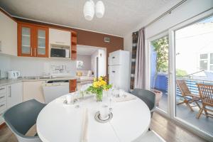 eine Küche und ein Esszimmer mit einem weißen Tisch und Stühlen in der Unterkunft Apartmani Gabriella in Vodice