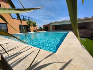 a swimming pool in front of a house at La Villa Nina in Mirepeisset