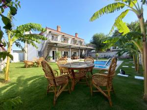 a patio with a table and chairs in front of a house at La Maison de Yasmine in Alaçatı