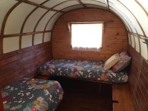 a small room with two beds and a window at Le Camping de Cucugnan in Cucugnan