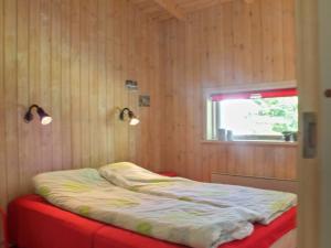 Ce lit se trouve dans un dortoir doté d'une fenêtre et de lumières. dans l'établissement Holiday Home Gerarda - 4km from the sea in NE Jutland by Interhome, à Læsø