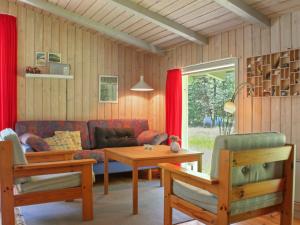 a living room with a couch and a table at Holiday Home Gerarda - 4km from the sea in NE Jutland by Interhome in Læsø
