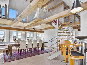 ein Esszimmer mit einem Tisch, Stühlen und einer Treppe in der Unterkunft Holiday Home Erik - 300m from the sea in Western Jutland by Interhome in Hvide Sande