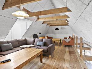 ein Wohnzimmer mit einem Sofa und einem Tisch in der Unterkunft Holiday Home Erik - 300m from the sea in Western Jutland by Interhome in Hvide Sande