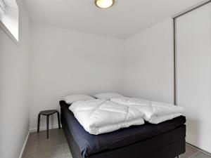 a bed with white sheets on it in a room at Holiday Home Gerniot - 500m from the sea in NE Jutland by Interhome in Frederikshavn