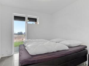 a bed sitting in a room with a window at Holiday Home Gerniot - 500m from the sea by Interhome in Frederikshavn