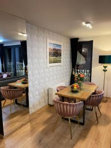 une salle à manger avec deux tables et des chaises ainsi qu'une cuisine dans l'établissement Rezydencja Strążyska, à Zakopane