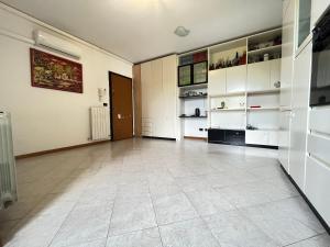 a large room with white cabinets and a tile floor at Gramsci suite home in Casa la Luna