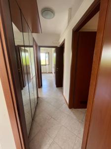 a hallway with mirrored doors and a tile floor at Gramsci suite home in Casa la Luna
