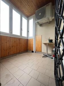 une pièce vide avec des fenêtres, une table et un ventilateur dans l'établissement Gramsci suite home, à Casa la Luna
