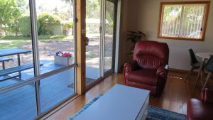 - un salon avec une chaise et une porte coulissante en verre dans l'établissement Four Seasons Waterfront Villas, à Taranna 17 autres photos