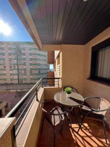 a balcony with a table and chairs on a balcony at Apartamento Playa Delicias in Águilas