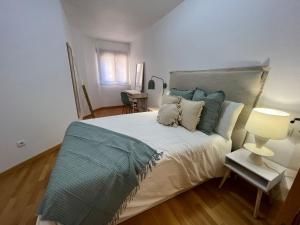 a bedroom with a large bed with blue pillows at Apartamento Playa Delicias in Águilas