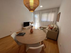 a living room with a table and a couch at Apartamento Playa Delicias in Águilas +5 photos