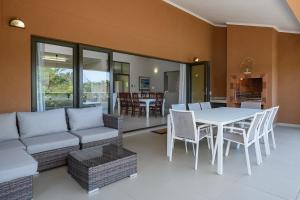 ein Wohnzimmer mit einer Couch und einem Tisch und Stühlen in der Unterkunft San Lameer Villa 14321 - 5 Bedroom Deluxe - 10 pax - San Lameer Rental Agency in Southbroom