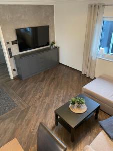 a living room with a television and a coffee table at Ferienhaus Bella Haus am Harkebrügger See in Barßel