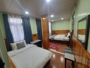 a hotel room with two beds and a mirror at Kanari B&B in Darjeeling