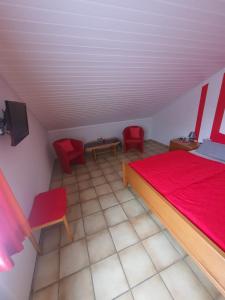 トリッテンハイムにあるWeingut Kirsten u. Kirstenのベッドルーム1室(赤いベッド1台、赤い椅子2脚付)