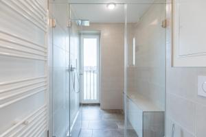 ein Badezimmer mit ebenerdiger Dusche und Glastür in der Unterkunft Ferienwohnung Ferhaaling mit direktem Seeblick in Nordstrand