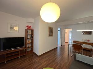 a living room with a flat screen tv and a table at August centro Tarragona in Tarragona