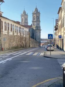 eine leere Straße mit einem Gebäude und einem Uhrturm in der Unterkunft In Lapa Studio I in Porto