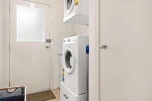 a white laundry room with a washer and dryer at Island Gem in Sunset Strip