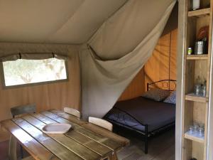 um quarto com uma cama e uma mesa numa tenda em Le Camping de Cucugnan em Cucugnan