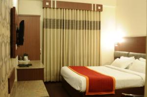 Hotel aroma classic في جايبور: غرفه فندقيه سرير كبير بغرفه