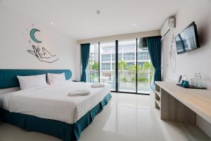 a bedroom with a bed and a large window at Moon Budget Hotel in Ao Nang Beach