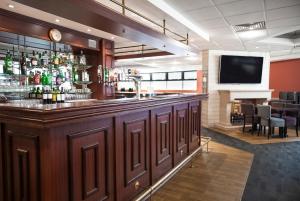 eine Bar in einem Restaurant mit TV dahinter in der Unterkunft Campanile Hotel Glasgow SECC Hydro in Glasgow