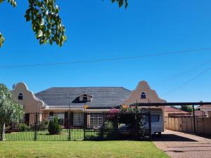 a house with a fence in the yard at Danrit Guesthouse - Uncapped wifi in Roodepoort