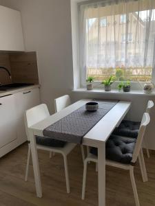 uma mesa branca e cadeiras numa cozinha com uma janela em Ferienwohnung Möwennest em Elmenhorst