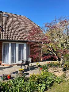 uma casa com um banco num quintal com flores em Ferienwohnung Möwennest em Elmenhorst