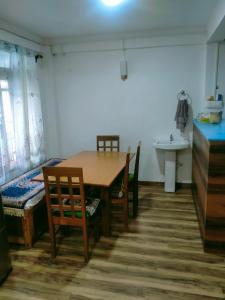 a dining room with a table and chairs and a sink at Ajit Homestay, Darjeeling in Darjeeling