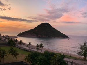 vista para uma ilha no oceano ao pôr-do-sol em Flat na Praia do Pontal com vista deslumbrante - Villa del Sol Residences no Rio de Janeiro