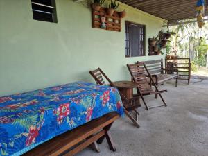 een slaapkamer met een bed en een tafel en stoelen bij Tranquilidade e vista privilegiada in Ilhabela