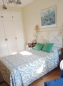 1 dormitorio con 1 cama con almohadas verdes en Costa Ballena Torresalada 1, en Costa Ballena