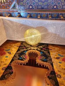a room with a large gold ball on a rug at Riad Dar Kassim in Fez