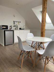 a white dining room with a table and chairs at Willa K52 in Siemiatycze