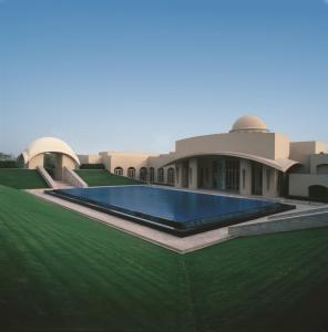 a house with a swimming pool in front of it at Trident Gurgaon in Gurgaon
