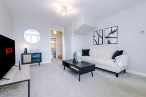 a living room with a white couch and a table at Lovely three bed home Manchester in Heywood